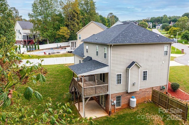 rear view of house with a patio area, a yard, and a wooden deck