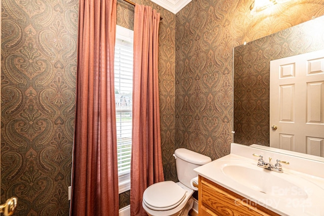 bathroom featuring vanity, toilet, and ornamental molding