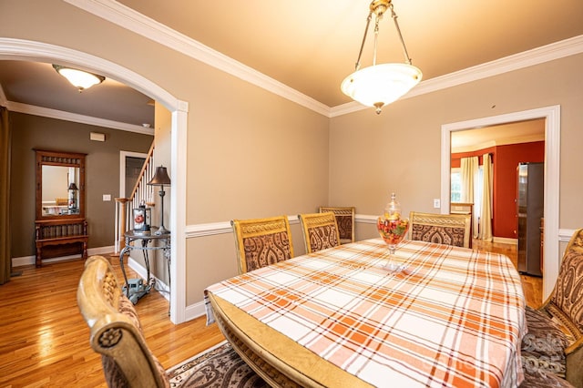 dining space with light wood-type flooring and crown molding