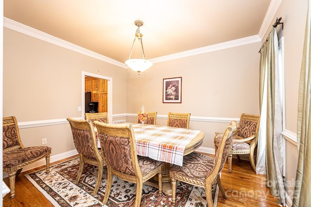 dining space featuring hardwood / wood-style floors and ornamental molding