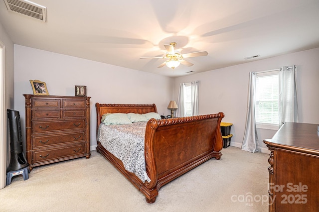 bedroom featuring ceiling fan, light colored carpet, and multiple windows