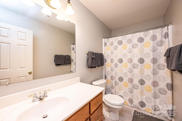 bathroom featuring vanity, toilet, and curtained shower