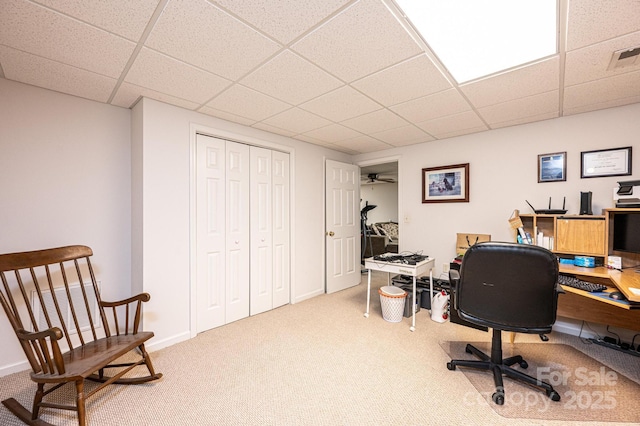 carpeted office featuring ceiling fan and a drop ceiling