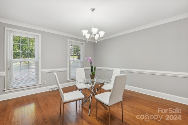 dining room featuring an inviting chandelier, ornamental molding, dark wood-type flooring, and a wealth of natural light