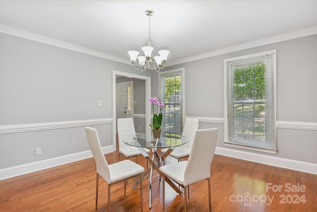 dining room with crown molding, hardwood / wood-style floors, and a chandelier