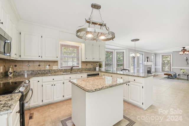 kitchen with a kitchen island, white cabinets, hanging light fixtures, and stainless steel appliances