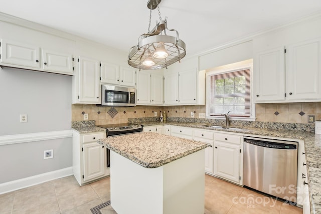 kitchen featuring appliances with stainless steel finishes, a center island, white cabinetry, and decorative light fixtures