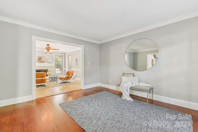 living area featuring crown molding and hardwood / wood-style flooring