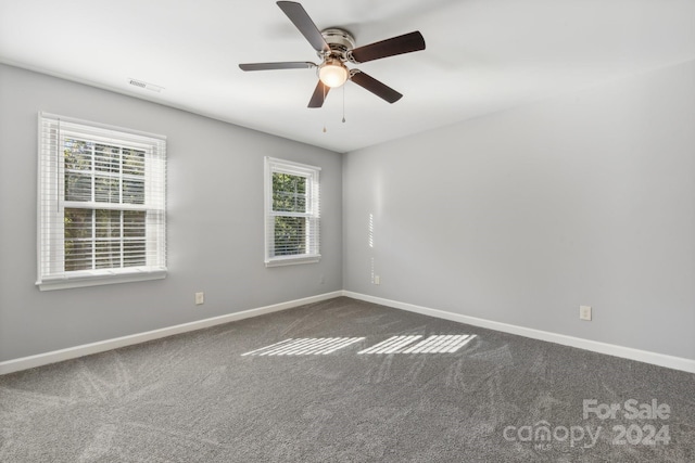 empty room featuring dark colored carpet and ceiling fan