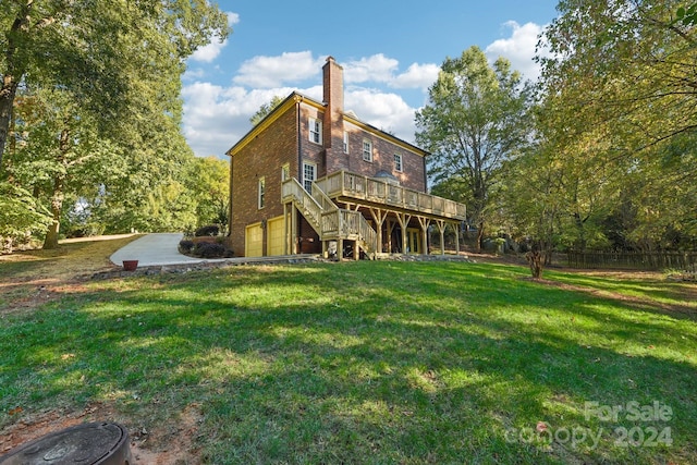 rear view of house with a wooden deck and a lawn