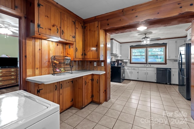 kitchen featuring light tile patterned flooring, wood walls, decorative backsplash, black appliances, and ceiling fan