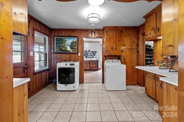 washroom featuring wooden walls, washer / clothes dryer, light tile patterned floors, and crown molding