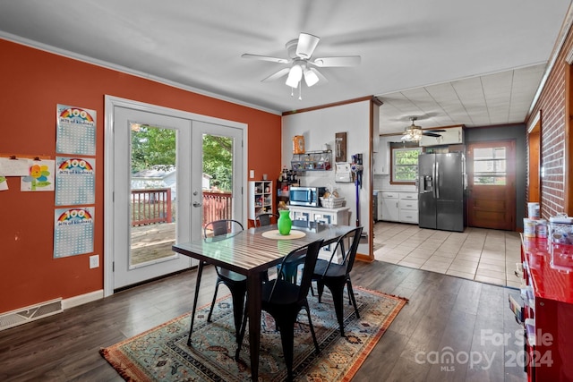 dining space featuring french doors, wood-type flooring, and a healthy amount of sunlight