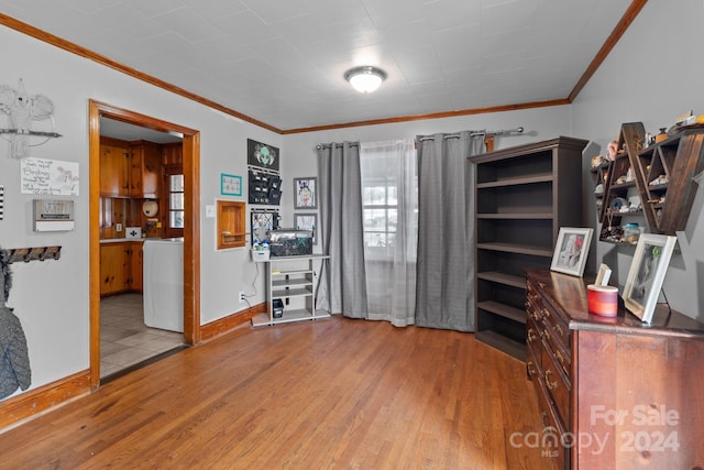 office space featuring light wood-type flooring, crown molding, and washer / clothes dryer