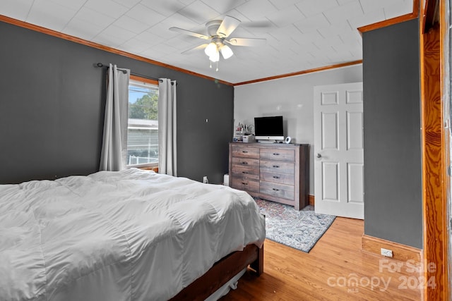 bedroom featuring wood-type flooring, ornamental molding, and ceiling fan