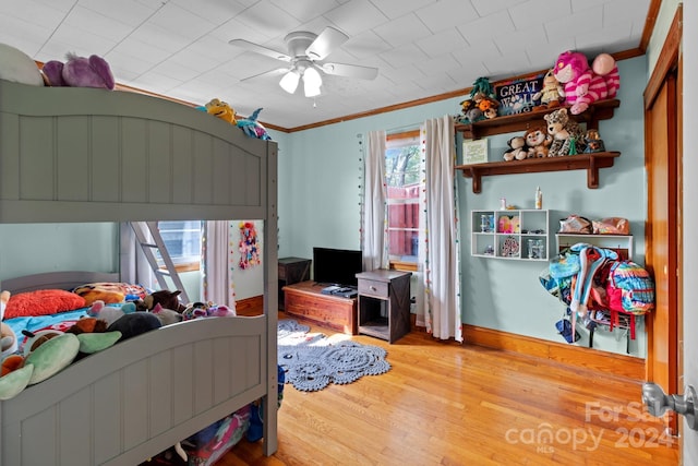 bedroom featuring ceiling fan, ornamental molding, and wood-type flooring