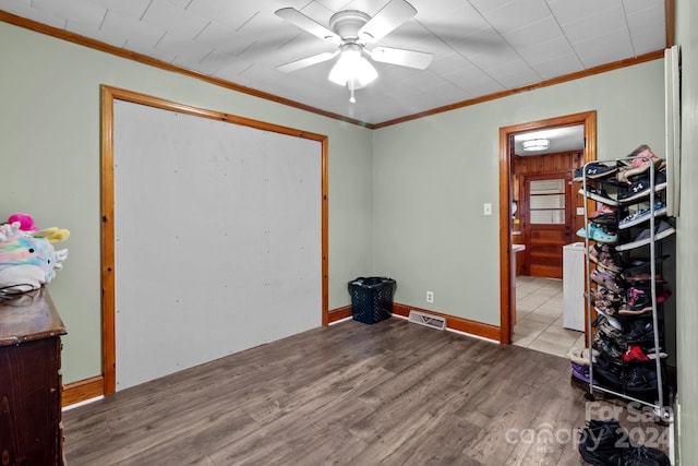 spare room featuring light hardwood / wood-style floors, ornamental molding, and ceiling fan