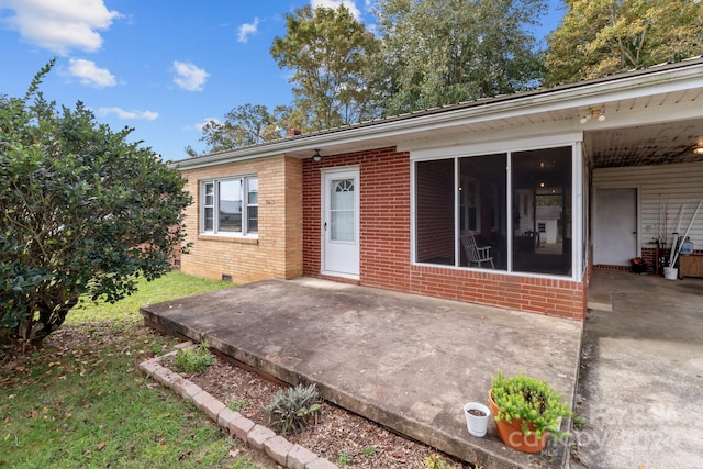 view of front facade featuring a sunroom and a patio