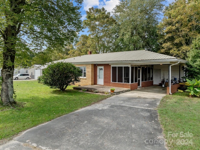 ranch-style home with a carport and a front lawn