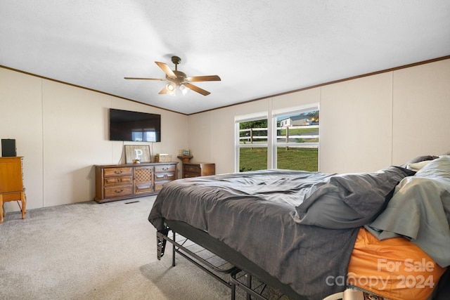 bedroom featuring vaulted ceiling, carpet floors, a textured ceiling, ornamental molding, and ceiling fan