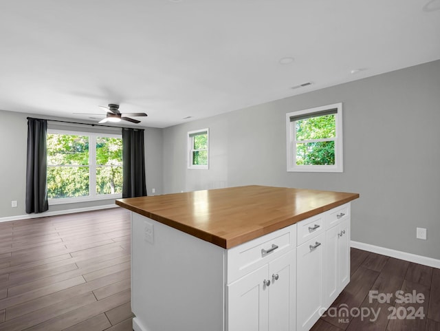 kitchen with butcher block countertops, plenty of natural light, white cabinets, and dark hardwood / wood-style floors