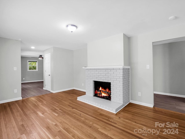 unfurnished living room featuring ceiling fan, a fireplace, and hardwood / wood-style floors