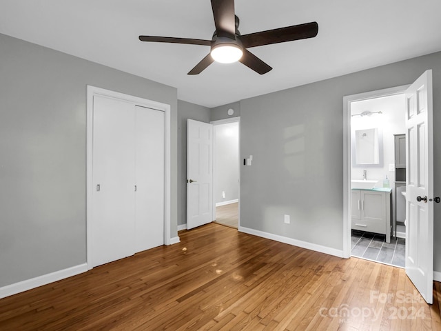 unfurnished bedroom with light hardwood / wood-style floors, a closet, ceiling fan, ensuite bathroom, and sink