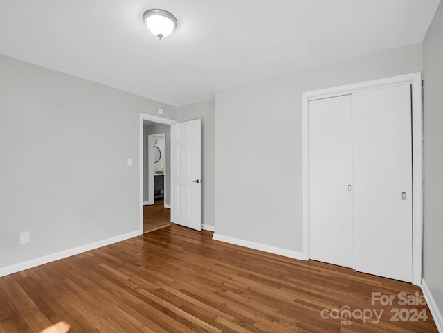 unfurnished bedroom with a closet and hardwood / wood-style flooring