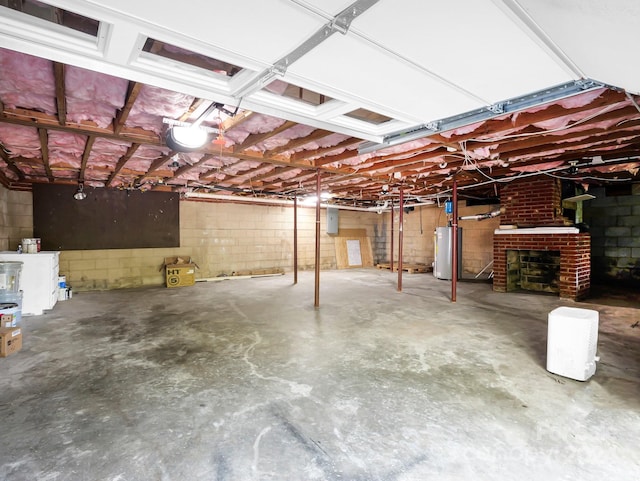 basement featuring water heater and a brick fireplace