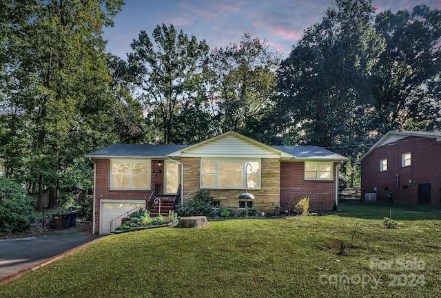 view of front of property featuring a yard and a garage