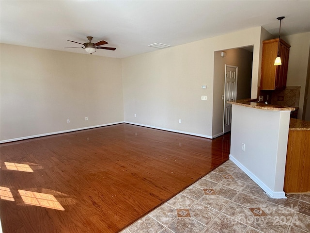 unfurnished living room with ceiling fan and dark hardwood / wood-style floors