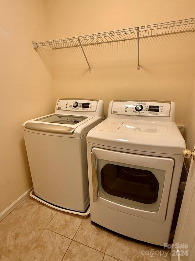 washroom featuring light tile patterned floors and washer and clothes dryer