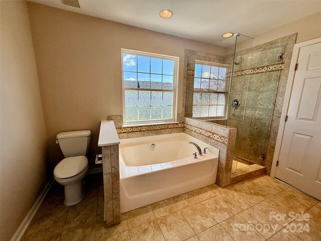 bathroom with plus walk in shower, tile patterned flooring, and toilet