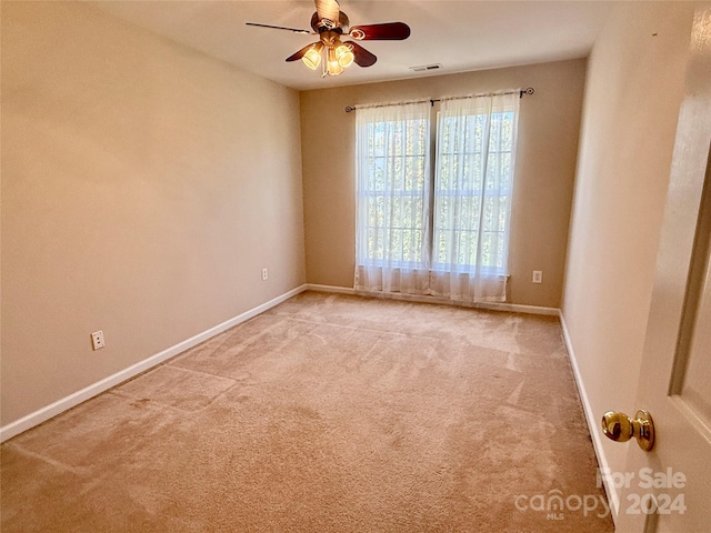 spare room with ceiling fan and light carpet