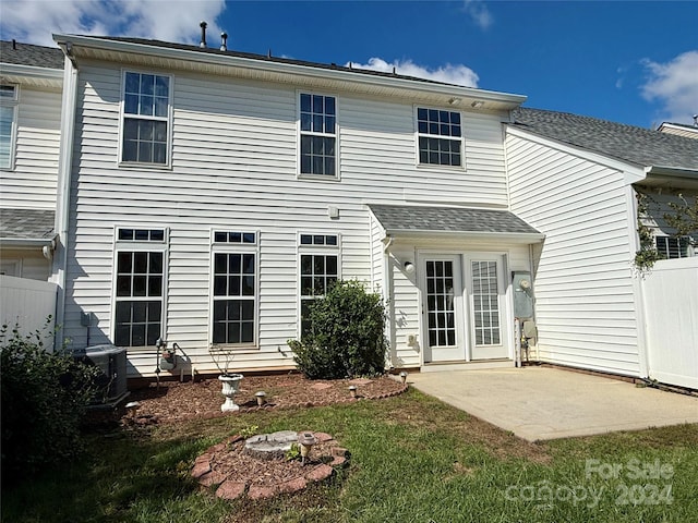 rear view of house with central AC unit, a yard, and a patio