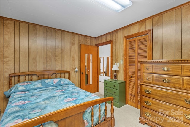 bedroom featuring carpet floors, wooden walls, and a closet