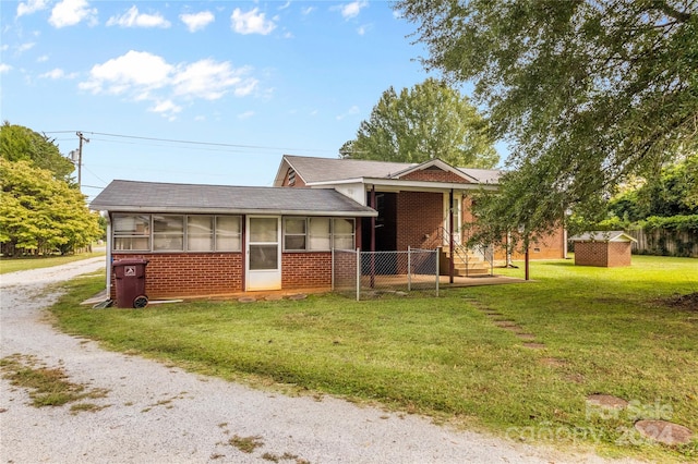 view of front of property featuring a sunroom and a front lawn