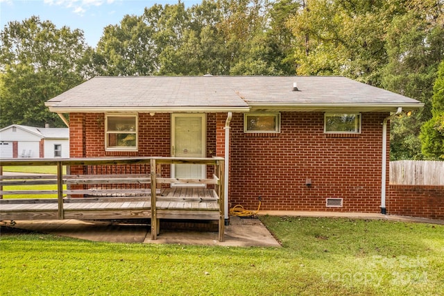 back of property with a lawn and a wooden deck