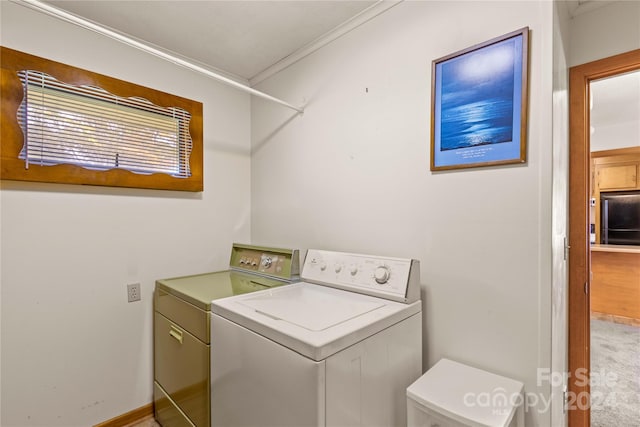 washroom featuring washer and clothes dryer and ornamental molding