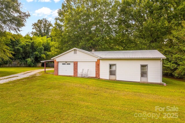 garage featuring a carport and a yard