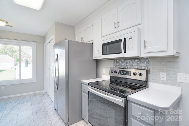kitchen featuring white cabinets, light countertops, appliances with stainless steel finishes, and marble finish floor