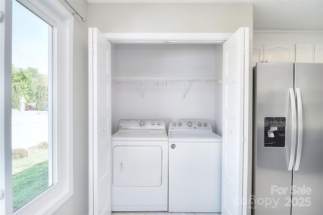 clothes washing area with laundry area, a healthy amount of sunlight, and separate washer and dryer
