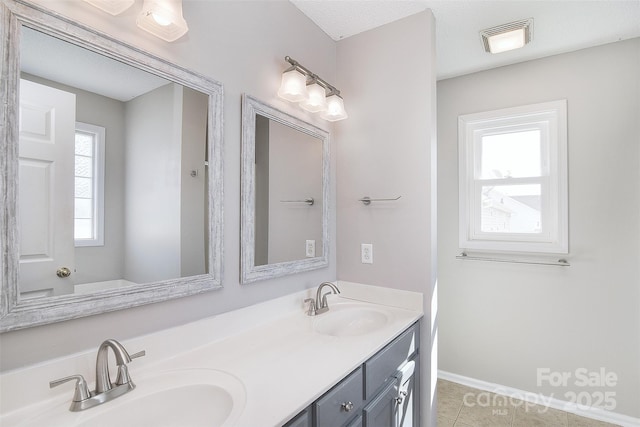 bathroom featuring tile patterned floors, double vanity, visible vents, and a sink