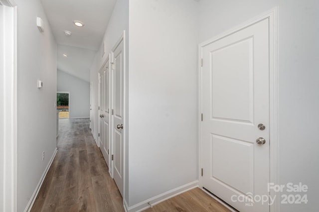 hall featuring lofted ceiling and dark wood-type flooring