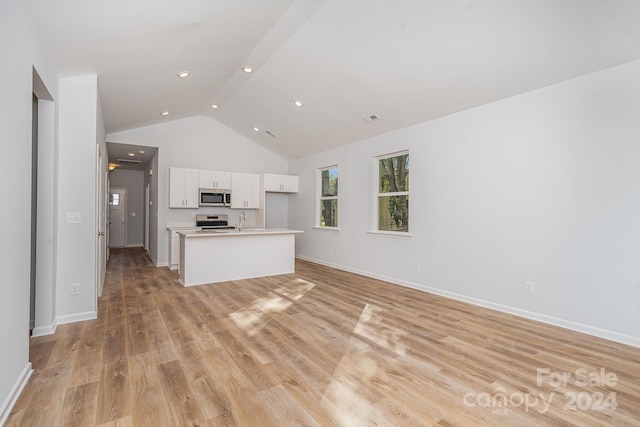 unfurnished living room featuring vaulted ceiling, light hardwood / wood-style floors, and sink