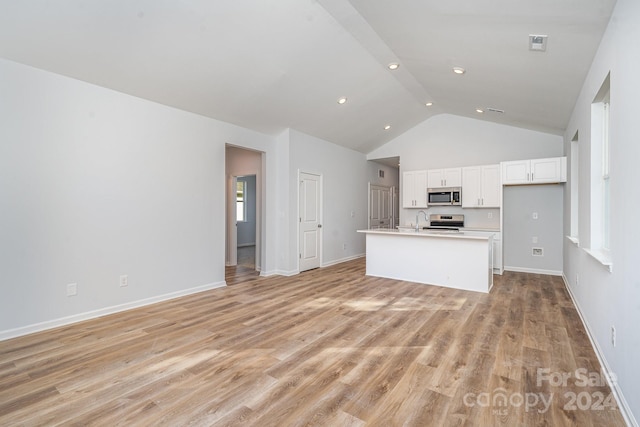 unfurnished living room with sink, light hardwood / wood-style floors, and vaulted ceiling