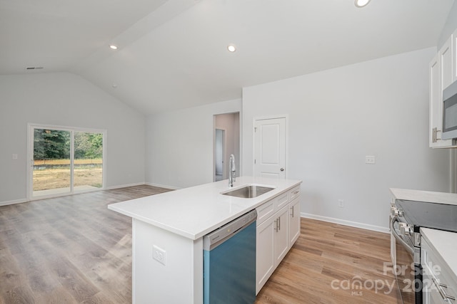 kitchen featuring sink, a center island with sink, white cabinetry, stainless steel appliances, and vaulted ceiling