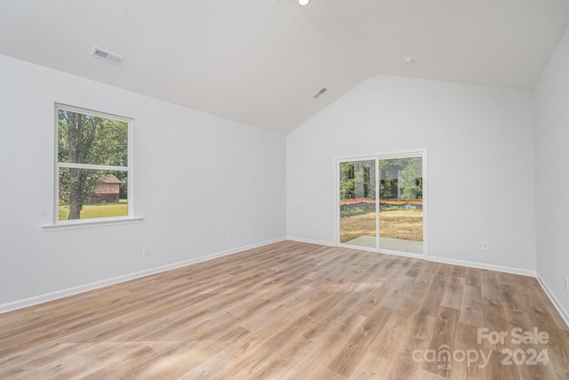 unfurnished room featuring light hardwood / wood-style flooring and vaulted ceiling