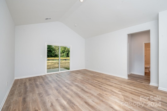 unfurnished room with light hardwood / wood-style flooring and vaulted ceiling