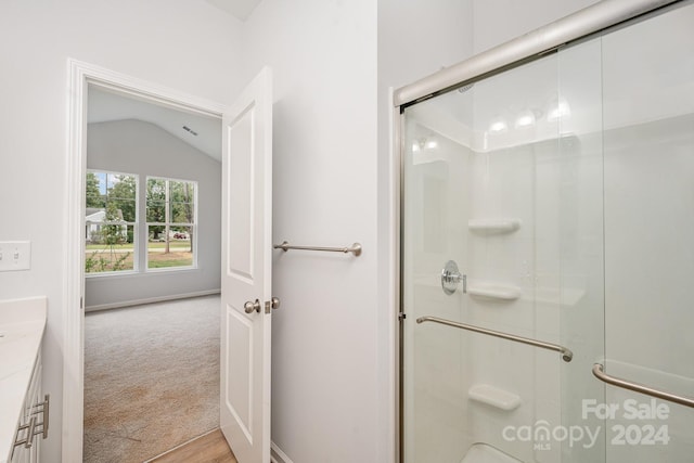 bathroom featuring vanity, lofted ceiling, hardwood / wood-style floors, and an enclosed shower